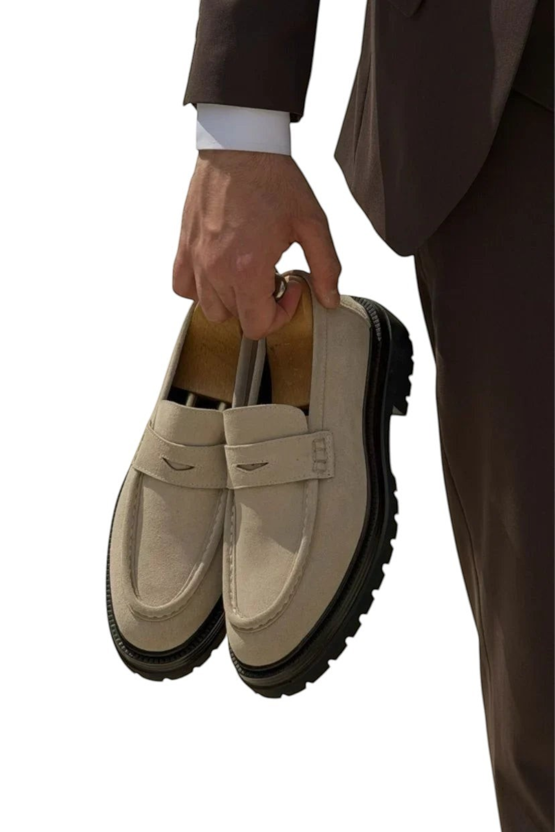 zevrion beige suede penny loafers with thick black rubber lug soles held by a man in a brown suit