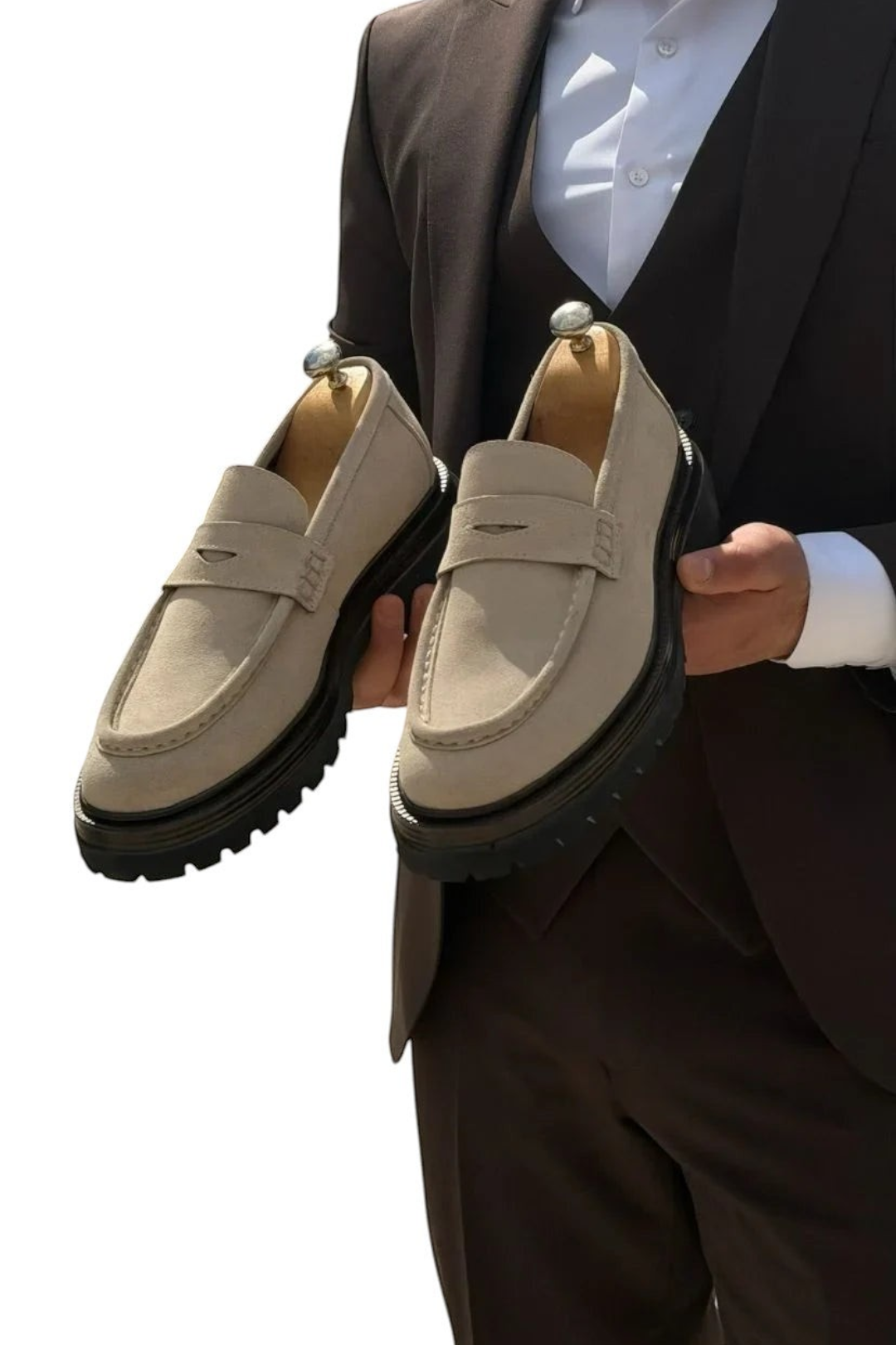 zevrion beige suede penny loafers with thick black rubber lug soles held by a man in a brown suit