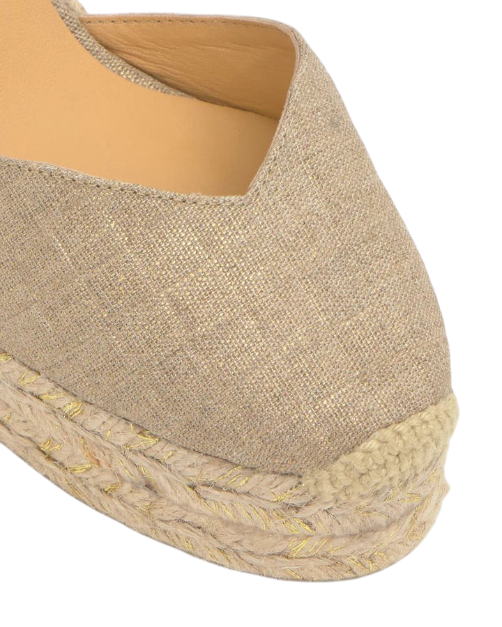 Close-up of zevrion beige wedge sandals featuring a woven jute platform sole and metallic gold thread detailing.