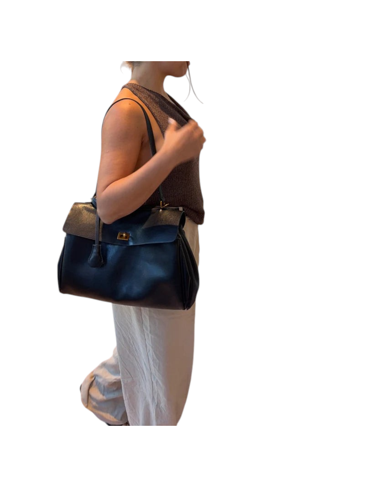 zevrion black leather XL tote bag for laptops worn over the shoulder by a woman in a casual outfit