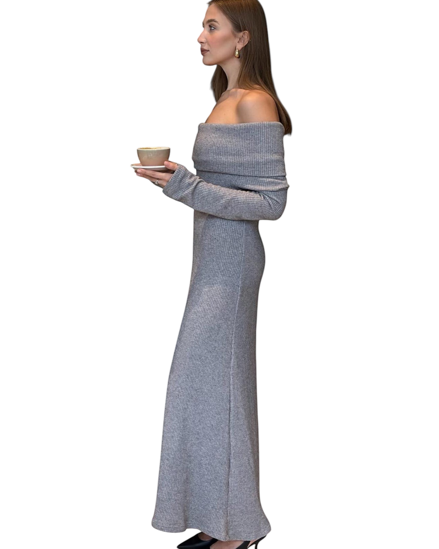 A woman wearing a zevrion grey off-the-shoulder ribbed knit maxi dress while holding a coffee cup, side view.